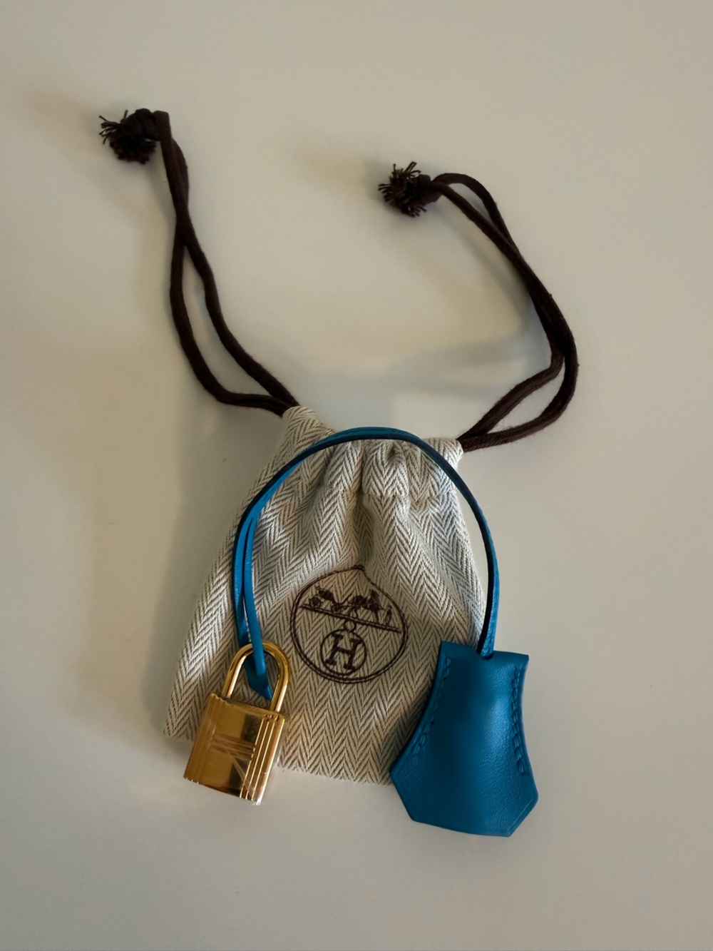 Hermès clochette with a gold-tone padlock and two keys and dust bag